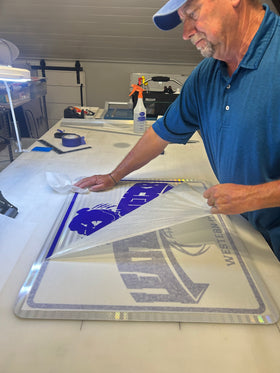 Peeling back the transfer material to reveal the applied graphics.