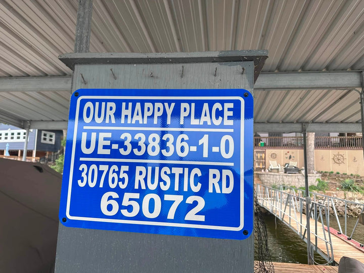 Our Happy Place — A personalized blue reflective identification sign installed on a lakeside dock.