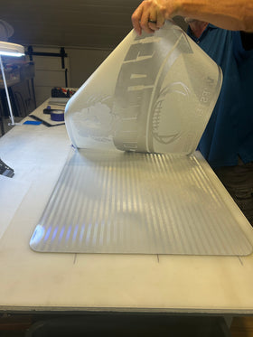 Positioning the cut-film design over the reflective panel.
